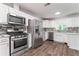 Well-equipped kitchen with stainless steel appliances, white cabinets, and stone backsplash at 4148 Kings Cswy, Ellenwood, GA 30294