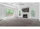 Spacious living room with fireplace, large windows, tray ceiling, and plush carpet flooring at 4148 Kings Cswy, Ellenwood, GA 30294