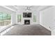 Spacious living room with fireplace, large windows, tray ceiling, and plush carpet flooring at 4148 Kings Cswy, Ellenwood, GA 30294