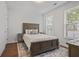 Well-lit bedroom with hardwood floors, a comfortable queen-size bed, and windows with natural light at 820 Kenway Ave, Roswell, GA 30076