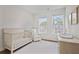 Bright Bedroom with hardwood floors, featuring a crib, comfortable chair, and ample natural light at 820 Kenway Ave, Roswell, GA 30076