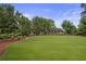 Expansive green common area surrounded by mature trees within the community at 820 Kenway Ave, Roswell, GA 30076