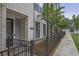 Street view of a brick townhome exterior with a well-maintained landscape and wrought iron fence at 820 Kenway Ave, Roswell, GA 30076