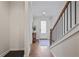 Inviting hallway featuring hardwood floors, wood railing staircase, and natural light from the front door at 820 Kenway Ave, Roswell, GA 30076