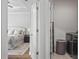 Convenient laundry area with folding doors, adjacent to a bedroom with a comfortable queen-size bed at 820 Kenway Ave, Roswell, GA 30076