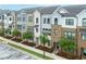 Charming townhome exteriors with varied brick and siding, complemented by tree-lined street at 820 Kenway Ave, Roswell, GA 30076