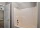 Bathroom shower and tub with tile surround, alongside a closed white door at 175 Hearth Way, Fairburn, GA 30213