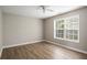 Bright bedroom featuring light brown flooring, neutral paint, and a large window, freshly renovated at 175 Hearth Way, Fairburn, GA 30213