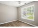 Cozy bedroom with wood-look floors, ceiling fan and a large window for ample natural light at 175 Hearth Way, Fairburn, GA 30213