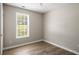 Bright bedroom featuring wood-look floors, neutral walls, ceiling fan, and a bright window at 175 Hearth Way, Fairburn, GA 30213