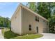 Side exterior of home showing the back entrance, garage, yard and green trees at 175 Hearth Way, Fairburn, GA 30213
