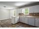 Bright kitchen with white cabinets, mosaic backsplash, and stainless steel sink, adjacent to the dining area at 175 Hearth Way, Fairburn, GA 30213