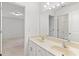 Bright bathroom with double vanity, large mirror, and white trim; connects to carpeted bedroom at 3366 Bridge Walk Dr, Lawrenceville, GA 30044