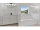 Bathroom features a sleek white vanity, a soaking tub, and a large window at 3366 Bridge Walk Dr, Lawrenceville, GA 30044