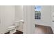 Convenient half-bathroom near the entrance, featuring a toilet and pedestal sink at 3366 Bridge Walk Dr, Lawrenceville, GA 30044