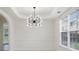 Elegant dining room with modern chandelier, white walls, tray ceiling, and large window at 3366 Bridge Walk Dr, Lawrenceville, GA 30044