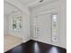 Elegant foyer with hardwood floors, white door with sidelights, and archway to the living space at 3366 Bridge Walk Dr, Lawrenceville, GA 30044
