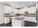 Beautiful kitchen with stainless appliances, tile backsplash, central island, and bright white cabinetry at 3366 Bridge Walk Dr, Lawrenceville, GA 30044