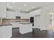 Spacious kitchen boasting white cabinets, a functional island, and stainless steel appliances, perfect for cooking at 3366 Bridge Walk Dr, Lawrenceville, GA 30044