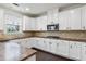 Modern kitchen featuring white cabinets, stainless steel appliances, and dark wood floors at 3366 Bridge Walk Dr, Lawrenceville, GA 30044