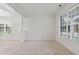 Bright living room with neutral carpet, white walls, large windows, and decorative columns at 3366 Bridge Walk Dr, Lawrenceville, GA 30044