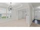 Inviting living room featuring neutral carpet, abundant windows, decorative columns, and modern chandelier at 3366 Bridge Walk Dr, Lawrenceville, GA 30044