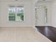 Cozy living room with a large window, neutral carpet, and entryway with beautiful dark wood flooring at 3366 Bridge Walk Dr, Lawrenceville, GA 30044