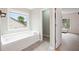 Bright bathroom boasts soaking tub, tile flooring, and a large window for natural light at 4092 Duran Ln, Auburn, GA 30011
