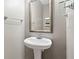 Charming pedestal sink in powder room with decorative mirror and lighting at 4092 Duran Ln, Auburn, GA 30011