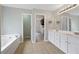Bathroom with tile floors, double sink vanity, soaking tub, and walk-in closet at 4092 Duran Ln, Auburn, GA 30011