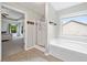 Well-lit bathroom with separate soaking tub and shower with backyard view at 4092 Duran Ln, Auburn, GA 30011
