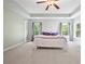 Large main bedroom with trey ceiling, ceiling fan, and windows with backyard view at 4092 Duran Ln, Auburn, GA 30011