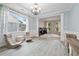 Bright sitting room featuring natural light, a chandelier, and an adjoining office space at 4092 Duran Ln, Auburn, GA 30011