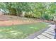 Backyard with retaining wall, lush greenery, and a view of the mature tree line at 1755 Waters Ferry Dr, Lawrenceville, GA 30043