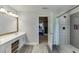 Bright bathroom features a modern tiled shower with built-in shelving, plank floors, and double sinks at 1755 Waters Ferry Dr, Lawrenceville, GA 30043