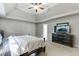 Bedroom features trey ceiling, ceiling fan, and dark wood furniture at 1755 Waters Ferry Dr, Lawrenceville, GA 30043