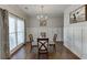 Elegant dining room featuring hardwood floors, wainscoting, modern chandelier, and large window at 1755 Waters Ferry Dr, Lawrenceville, GA 30043