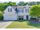 Charming two-story white brick home with black shutters, manicured lawn, and mature trees at 1755 Waters Ferry Dr, Lawrenceville, GA 30043