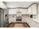 Updated kitchen with stainless steel appliances, white cabinets, and marble backsplash at 2554 Saint Patrick Se St, Atlanta, GA 30317