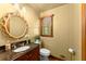 Cozy bathroom with a round mirror, granite vanity, and decorative lighting fixtures and window at 2841 Landing Dr, Marietta, GA 30066