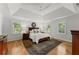 Serene main bedroom featuring a tray ceiling, ceiling fan and hardwood floors and multiple windows at 2841 Landing Dr, Marietta, GA 30066