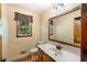 Cozy bathroom featuring a wood-framed mirror and a window with natural light at 3625 Stonehenge Ne Way, Marietta, GA 30066