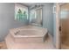 Serene bathroom with a large soaking tub, tiled flooring, and natural light at 3625 Stonehenge Ne Way, Marietta, GA 30066