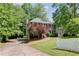 Traditional two-story home boasts a beautiful front yard with mature trees and meticulous landscaping at 3625 Stonehenge Ne Way, Marietta, GA 30066