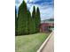 Landscaped entrance to The Courtyards at Towne Lake features a brick sign and mature evergreen trees at 401 Courtyard Ter, Woodstock, GA 30189