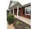 Welcoming brick home with white columns, a covered porch, and a beautifully landscaped yard at 401 Courtyard Ter, Woodstock, GA 30189