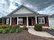 Charming brick home with black shutters, a covered porch, and manicured landscaping at 401 Courtyard Ter, Woodstock, GA 30189