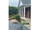 Home's exterior featuring brick, a porch with stately white columns, and manicured landscaping at 401 Courtyard Ter, Woodstock, GA 30189