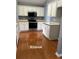 Well-equipped kitchen with white cabinets, stainless steel appliances, and hardwood floors at 401 Courtyard Ter, Woodstock, GA 30189