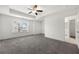 Spacious bedroom with tray ceiling, fan, plush gray carpet, and ample natural light at 5365 Radford Loop, Fairburn, GA 30213